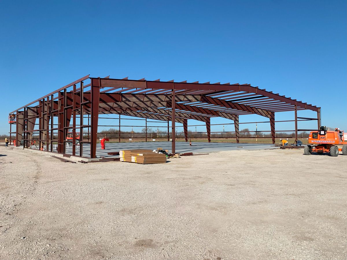 contractors erecting pre-engineered metal airplane hangar